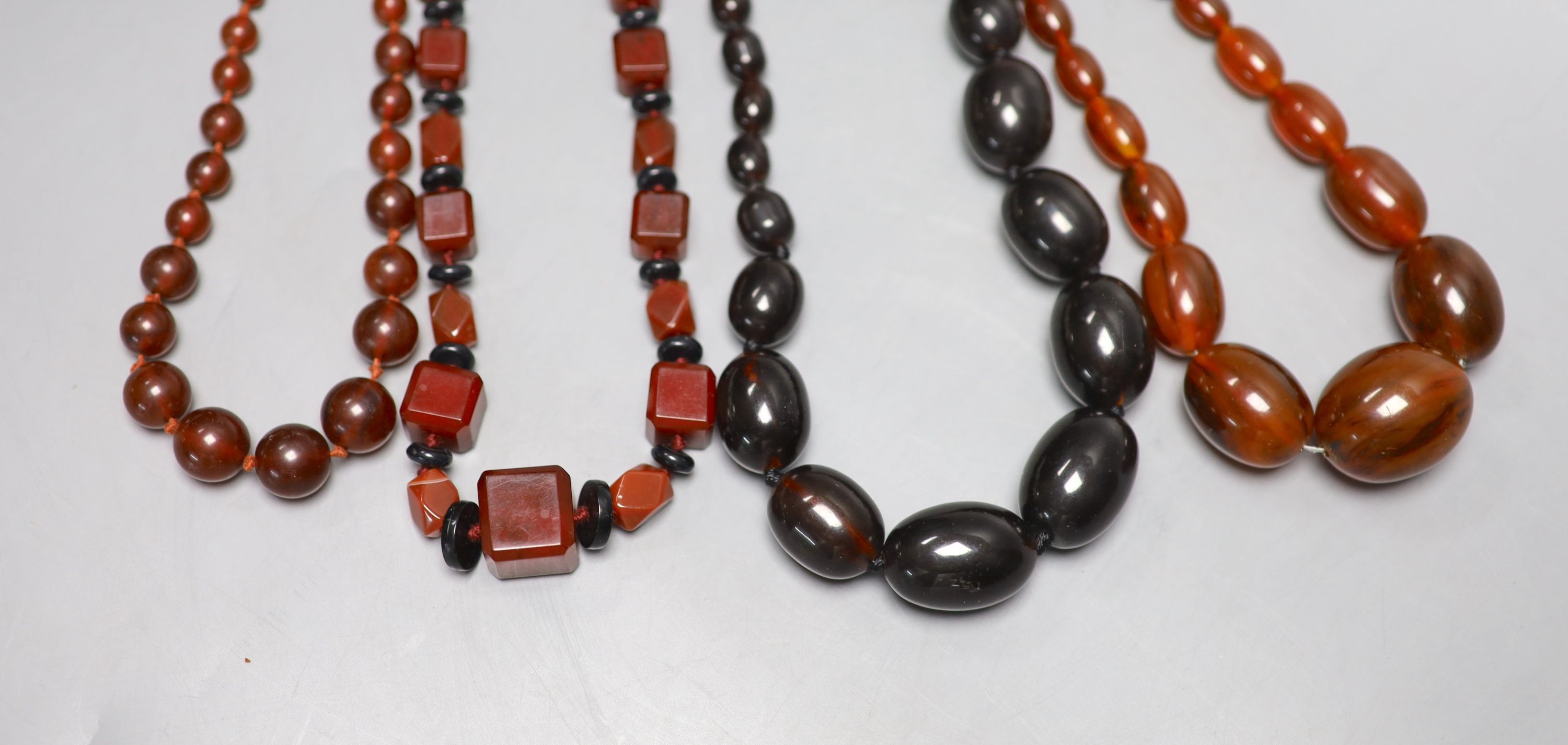 Four assorted simulated amber bead necklaces, largest 62cm.